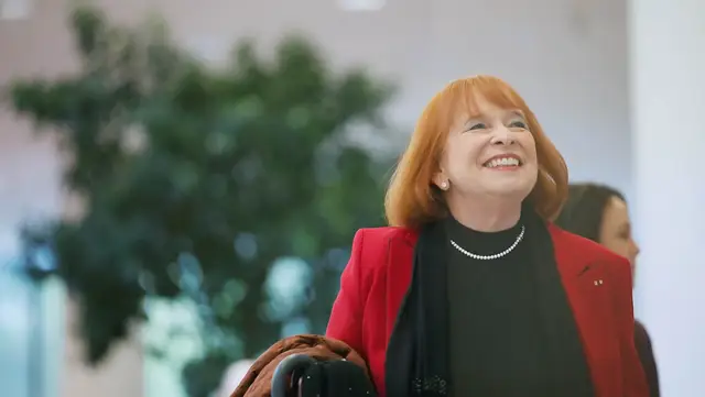 Ingrid Hofmann, Geschäftsführerin, im roten Blazer, blickt selbstbewusst und glücklich in die Zukunft bei Hofmann Personal.