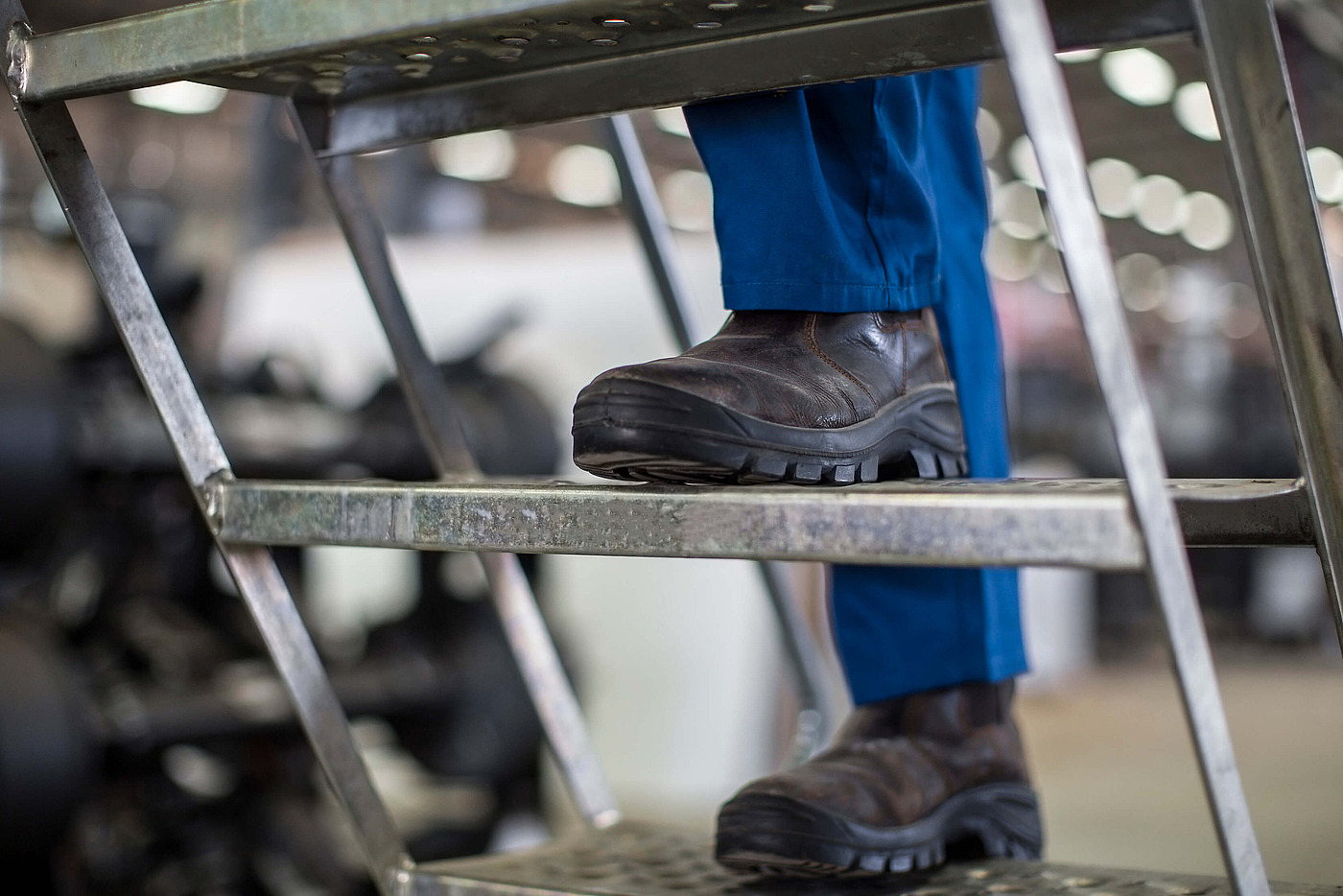 Mitarbeiterin mit Warnweste füllt Unterlagen aus und sitzt in einem Schulungsraum