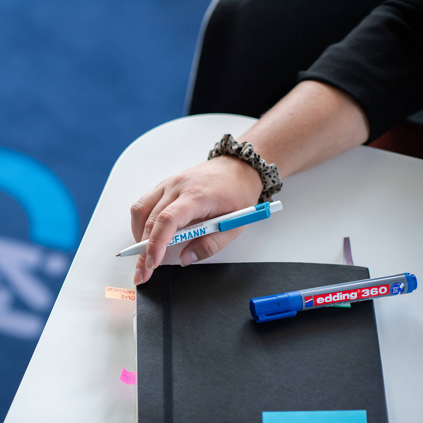 Schreibtisch im Büro von Hofmann Personal mit Kugelschreiber, Textmarker und Notizbuch.