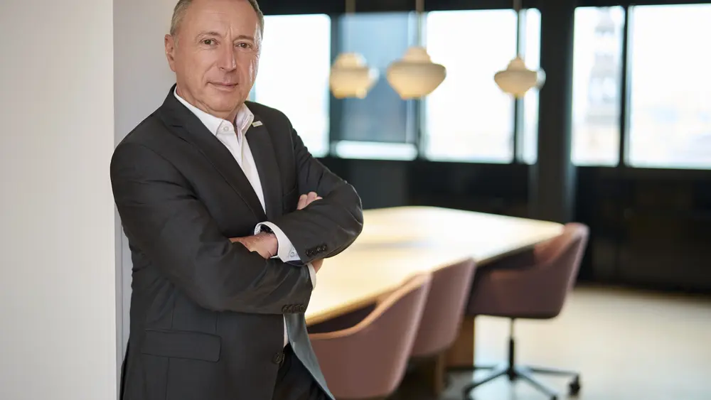 Mitglied des Executive Committee in Businesskleidung vor einem modernen Konferenzraum